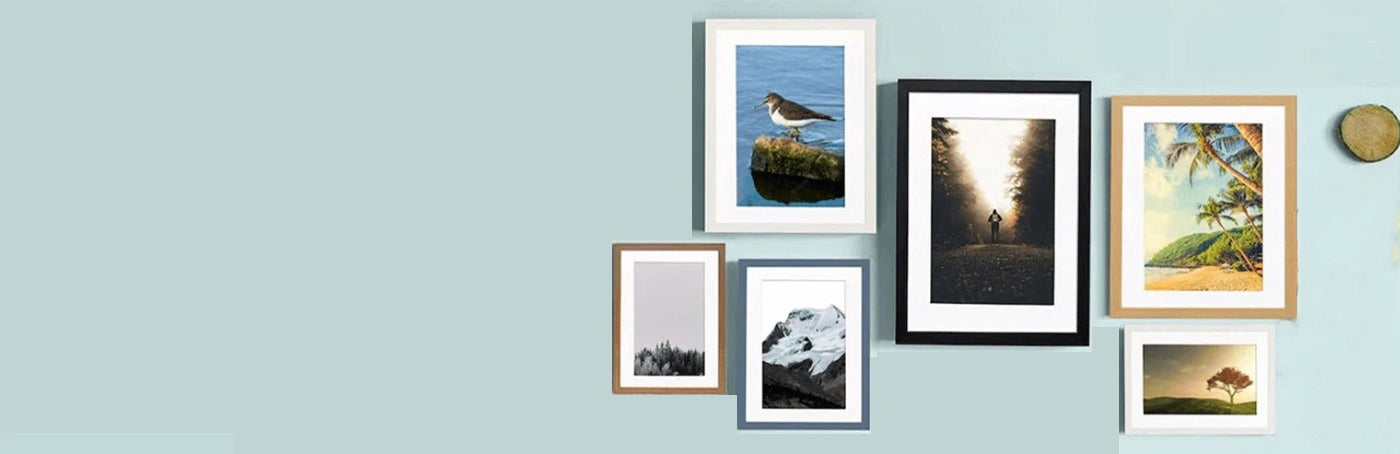 Multiple sizes Picture frames are hanging on a Light  blue wall.