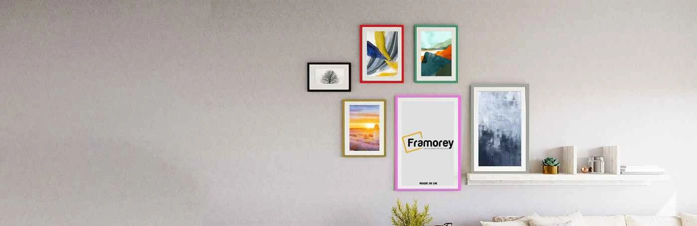 Six picture frames with different colors and sizes are hanging on a wall with some pictures and one frame has a Framorey logo inside it.