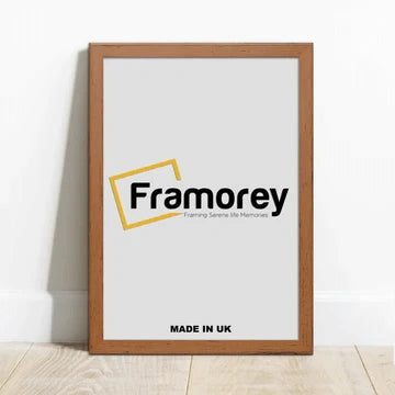 walnut Picture frame with a Framorey logo is standing with the wall on a wooden surface.